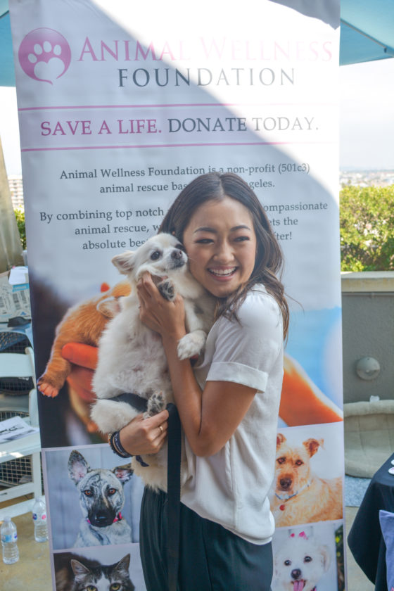Amy Okuda takes a minute to play with dogs available for adoption at LA-based Animal Awareness animal rescue